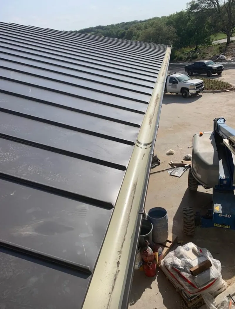 Standing seam panel and gutter detail on a metal roofing jobsite in Osprey